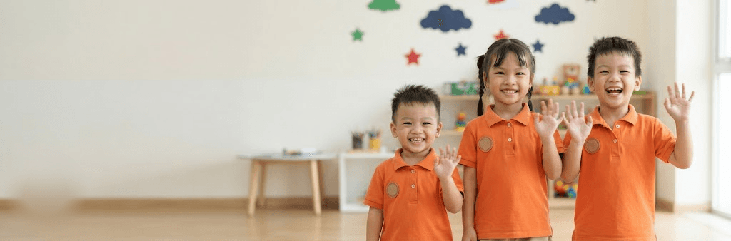 Bé NYE mặc áo đồng phục cam